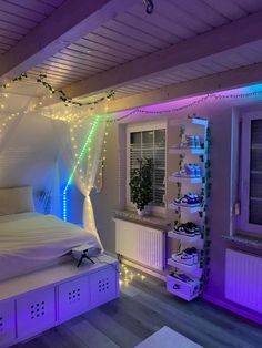 a bedroom decorated in white and purple lights