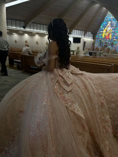 a woman in a wedding dress sitting at the alter looking over her shoulder and back