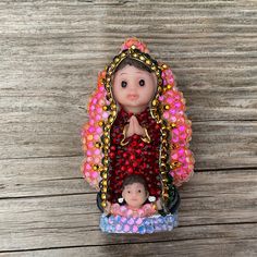 a small figurine is sitting on top of a wooden table next to a doll