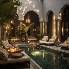 an indoor swimming pool with candles lit in the center and lounge chairs around it, surrounded by palm trees