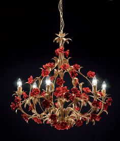 a chandelier with red flowers hanging from it's center, on a black background