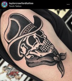 a skull wearing a top hat with a beard and mustache tattoo on the left arm