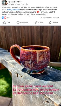 a coffee cup sitting on top of a wooden table next to a fence and grass