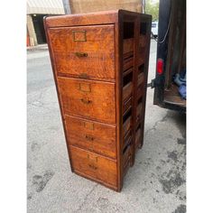 an old wooden filing cabinet sitting on the sidewalk