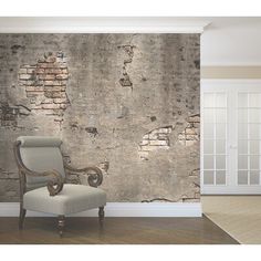 an old brick wall with peeling paint on it and a chair in the foreground