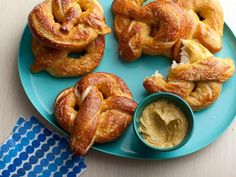 some pretzels on a blue plate with dipping sauce