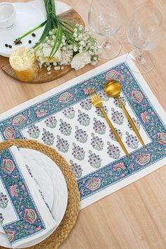 the placemats on the table are decorated with flowers and gold utensils