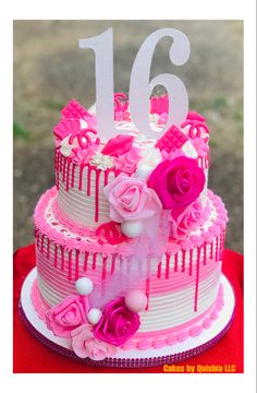 a birthday cake decorated with pink and white frosting, roses and icing on top