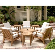 a wooden table sitting on top of a patio next to some chairs and a coffee table