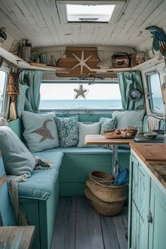 the inside of a camper with blue furniture and decor on the walls, along with wooden flooring