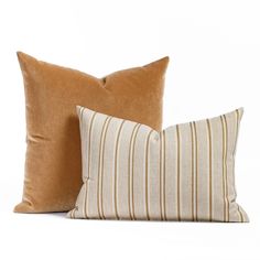 two brown and white pillows sitting next to each other