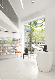 an empty pharmacy with lots of bottles on the counter and chairs in front of it