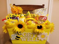 a yellow basket with sunflowers and candy in it that says get well soon