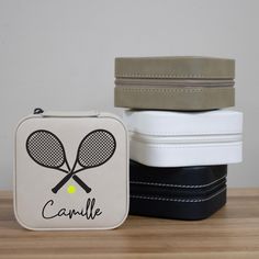 two tennis rackets sitting next to each other on top of a wooden table in front of a white case