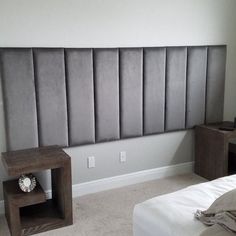 a room with a bed, nightstands and a headboard made out of concrete blocks