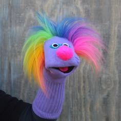 a person wearing a colorful wig and hand puppet