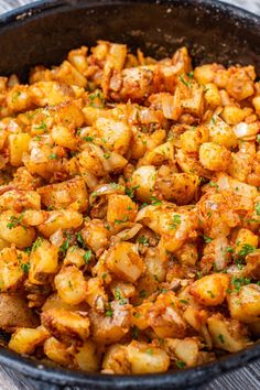 a pan filled with cooked potatoes on top of a wooden table