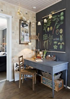 a room with a chalkboard on the wall next to a wooden table and two chairs