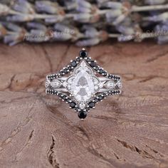 a white diamond ring sitting on top of a piece of wood