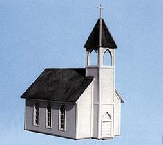 a white and black church steeple with a cross on it's roof against a blue sky