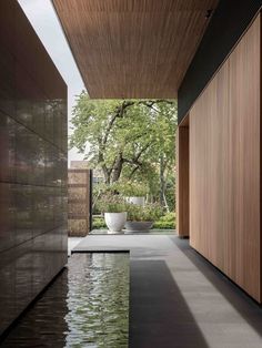 an empty pool in the middle of a room with wooden walls and floor to ceiling windows