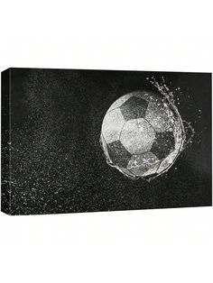 a black and white photo of a soccer ball in the air with water splashing around it