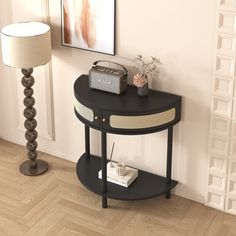 a black table with a radio on it next to a lamp and a framed photograph