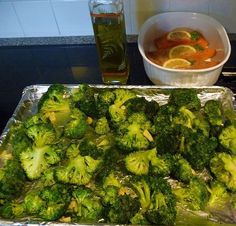 broccoli and lemon slices on tin foil with a bowl of soup in the background