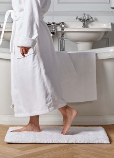 a person in a bathrobe standing on a towel