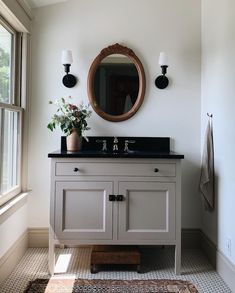 a bathroom with a sink, mirror and rug on the floor in front of it