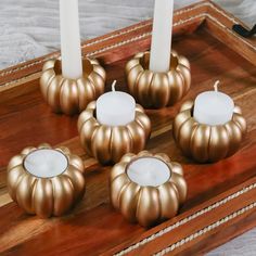 four candles sitting on top of a wooden tray