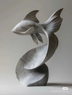 a metal sculpture that looks like a fish with its tail curled in the shape of a spiral