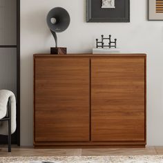 a living room with pictures on the wall and a wooden cabinet in front of it