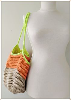 a crocheted bag hanging from the back of a mannequin's torso