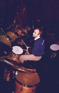 a man sitting on top of a drum set