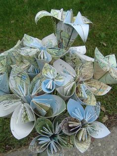 a bunch of origami flowers sitting in the grass