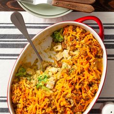 a casserole dish with broccoli, cheese and meat in it on a striped place mat