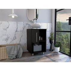 a white sink sitting next to a black cabinet in a bathroom under a large window