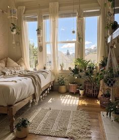 a bed sitting in a bedroom next to two windows with potted plants on them