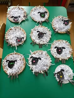 sheep made out of paper plates sitting on top of a green table