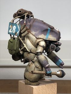 an old, rusty robot is holding a number 28 sign on it's back