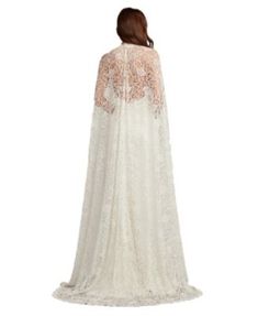 a woman wearing a white wedding gown with an open back and lace detailing on the sleeves