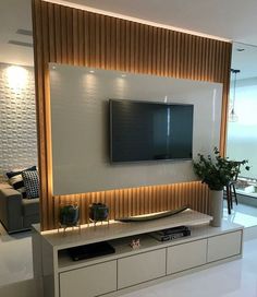 a flat screen tv mounted to the side of a white wall in a living room