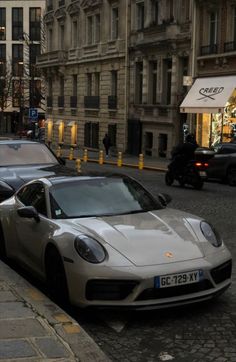 there is a white porsche parked on the side of the street