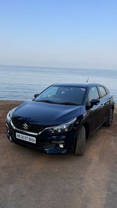 a blue car parked on the side of a beach