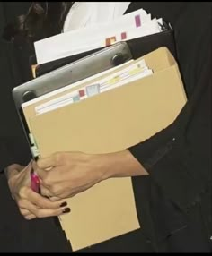 a woman holding a folder and pen in her hand