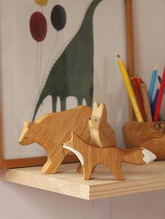 two wooden toy animals on a shelf with pencils