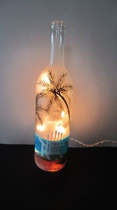 a lighted bottle with a palm tree in it