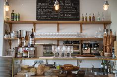 a counter with wine glasses, bread and other food items on it in a restaurant