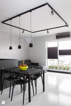 a dining room table with chairs and a bowl of fruit on it